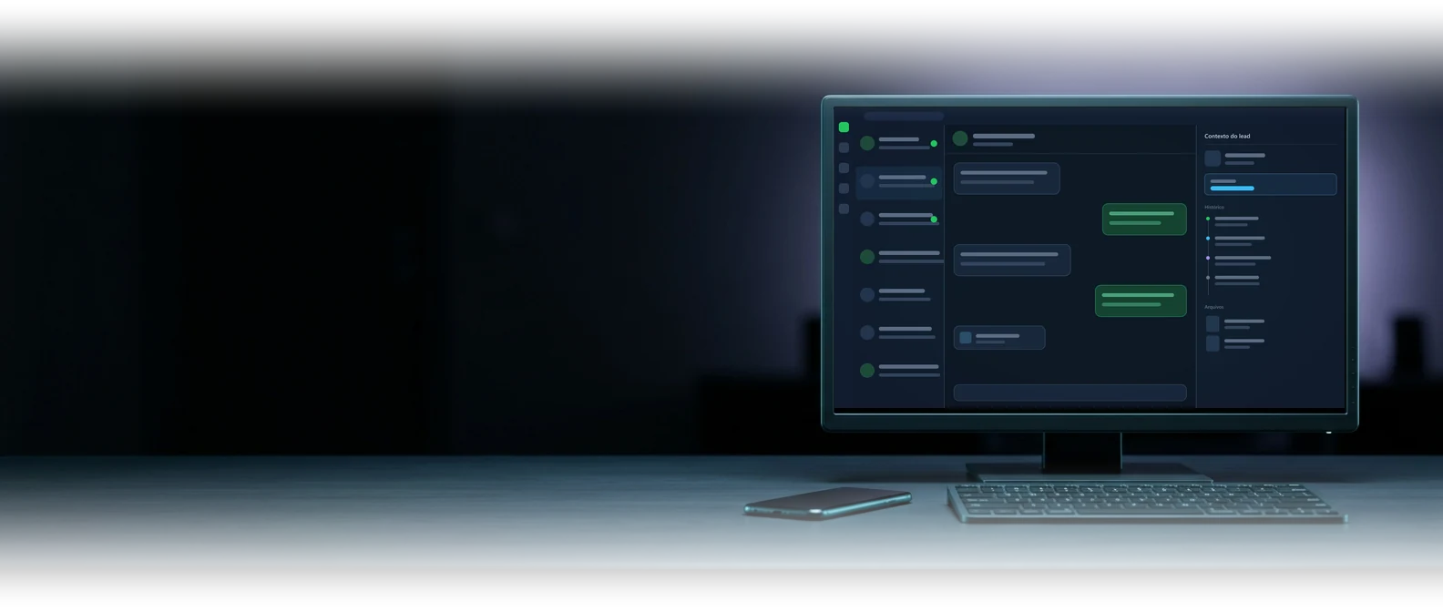Mesa à noite com o celular parado e o monitor mostrando a caixa de atendimento do CRM, com lista de conversas e diálogo